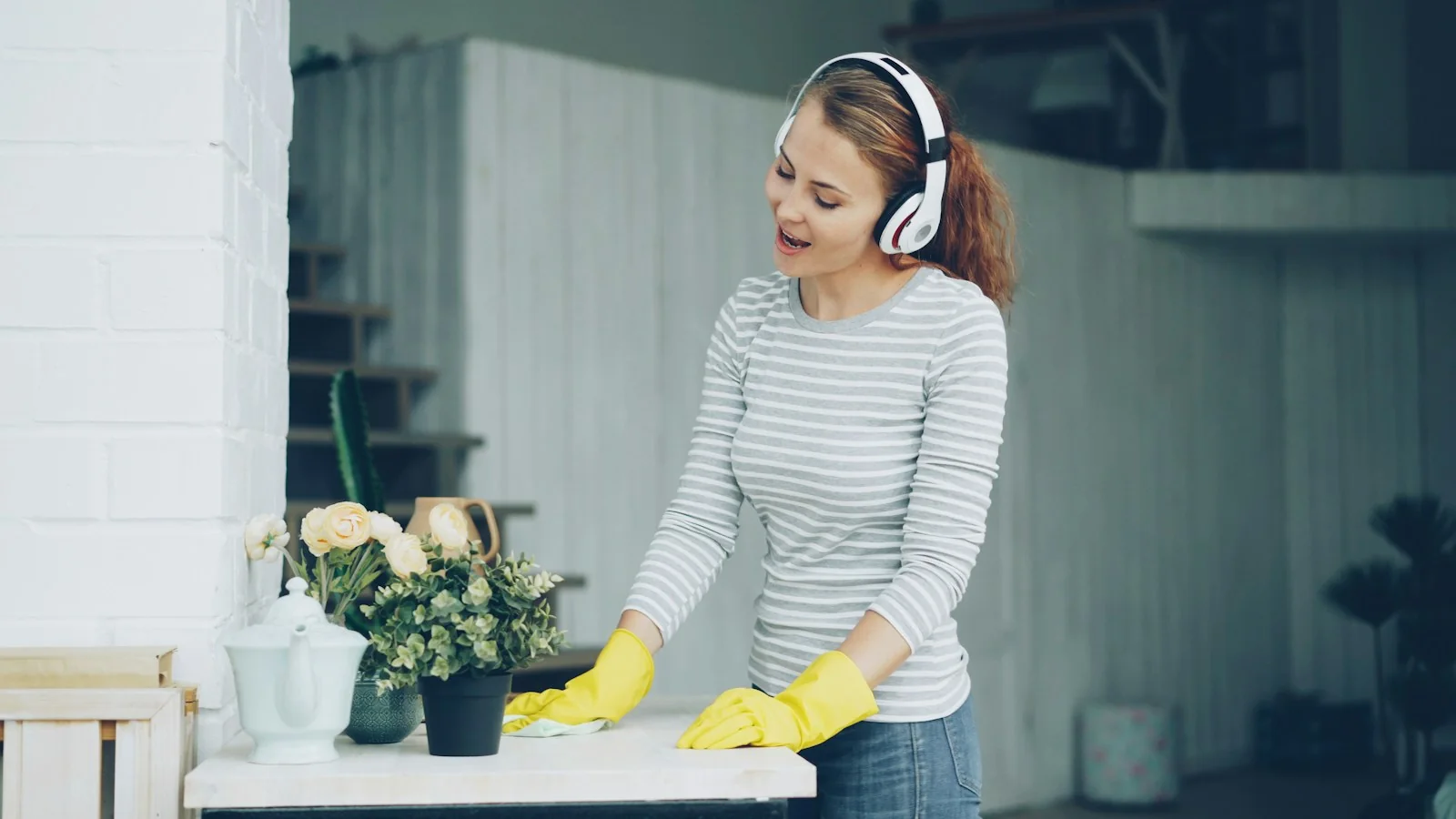 A cleaner smiling while wiping down a table in a bright room